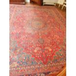 A red ground Tabriz carpet, decorated with teardrop medallion to centre within foliate design,