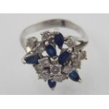 A white metal diamond and sapphire flowerhead cluster dress ring high claw set with pierced
