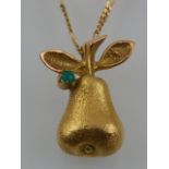 A yellow metal pendant in the form a pear, set with an emerald and stamped 14ct,