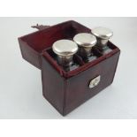 A George V tan leather toilet case containing three silver mounted glass bottles Finnegans Ltd,