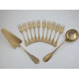 A French silver gilt cake slice and 16 oz ten matching cake forks with cast bell husk decoration,