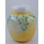 An early 20th century Ruskin pottery ginger jar and cover decorated with leaf branches on a yellow