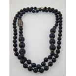 A designer single strand black hardstone necklace, possibly obsidion, the two size stones divided by