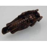 A Japanese Meiji carved boxwood netsuke modelled as a grasshopper L 7 cms bears character mark