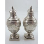 A pair of Continental silver Neo-Classical style sugar castors, the baluster bodies embossed oval