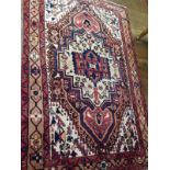 A Shivan rug, with a central motif on an ivory ground with stylised birds and flowers enclosed by