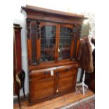 An early Victorian rosewood bookcase, the glazed upper section flanked by blind fret panels over two