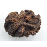 A Japanese Meiji carved boxwood netsuke modelled as a coiled octopus W 4 cms bears character mark