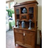 An early 20th century continental cupboard, the raised back with a pair of glazed panel doors