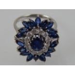 A diamond and sapphire cluster dress ring the circular, oval and pear shaped stones claw set in an