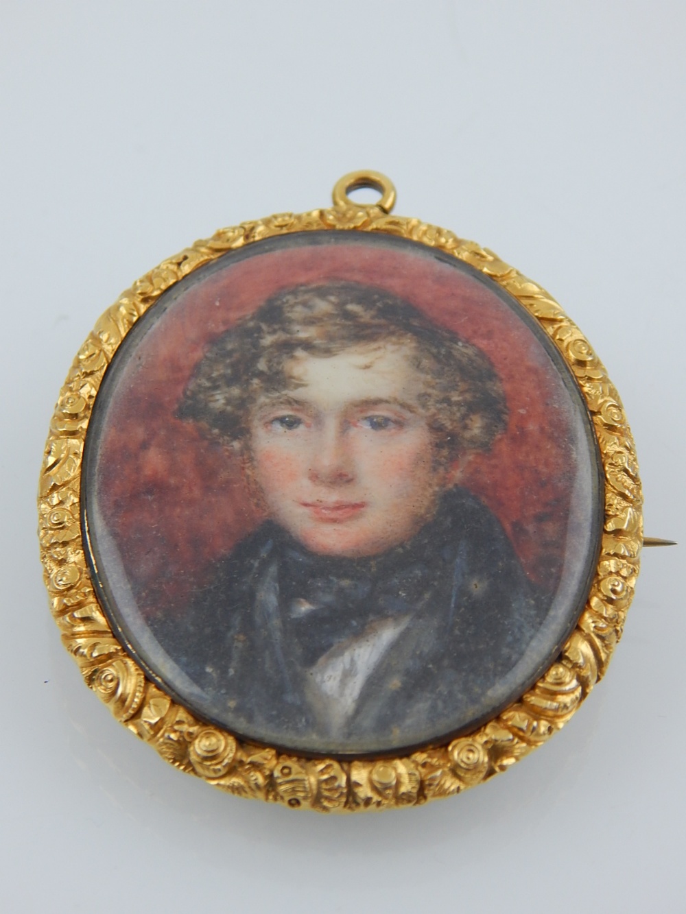 A 19th century yellow metal mounted pendant brooch, set portrait miniature, depicting a young - Image 3 of 5