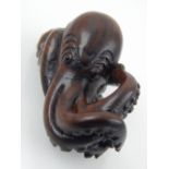 A Japanese Meiji carved boxwood netsuke modelled as a coiled octopus L 7 cms, beards character