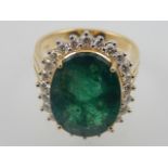 An 18 carat yellow gold, diamond, and emerald cluster ring, set large emerald of 8.90 carats,