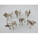 A set of six white metal menu holders, modelled as elephants, lions and camels. (6)