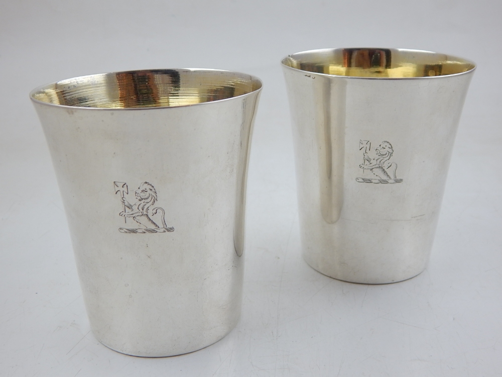 A pair of George III silver beakers, engraved armorials with gilt interiors, London 1766, by David
