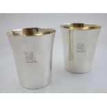 A pair of George III silver beakers, engraved armorials with gilt interiors, London 1766, by David