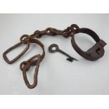 A pair of 19th century iron jailers shackles, together with key.