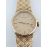 A ladies 9ct Omega bracelet wristwatch, the textured oval champagne dial with baton markers,