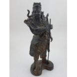 A Chinese bronze figure of a warrior in traditional dress. H. 28cm