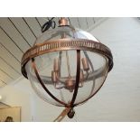 A modern copper spherical glass hall lantern, with pineapple finial.