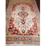 A Turkish silk rug, the central medallion on an ivory ground with foliate spandrels and within a