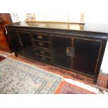 A contemporary oriental black lacquer cabinet, the rectangular top above an arrangement of four