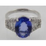 An 18 carat white gold, diamond, and tanzanite ring, set oval cut tanzanite of 3.0 carats, the