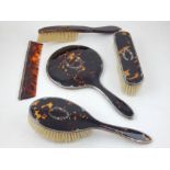 A silver and tortoiseshell dressing table set, London 1936, comprising hand mirror, two brushes