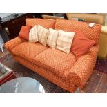 A modern designer three seater scroll arm sofa upholstered in patterned red and gold fabric with