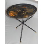 A Toleware style table, having circular top decorated with a Chinese village scene,