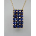 A 9ct gold and sapphire set rectangular pendant, with yellow metal chain.