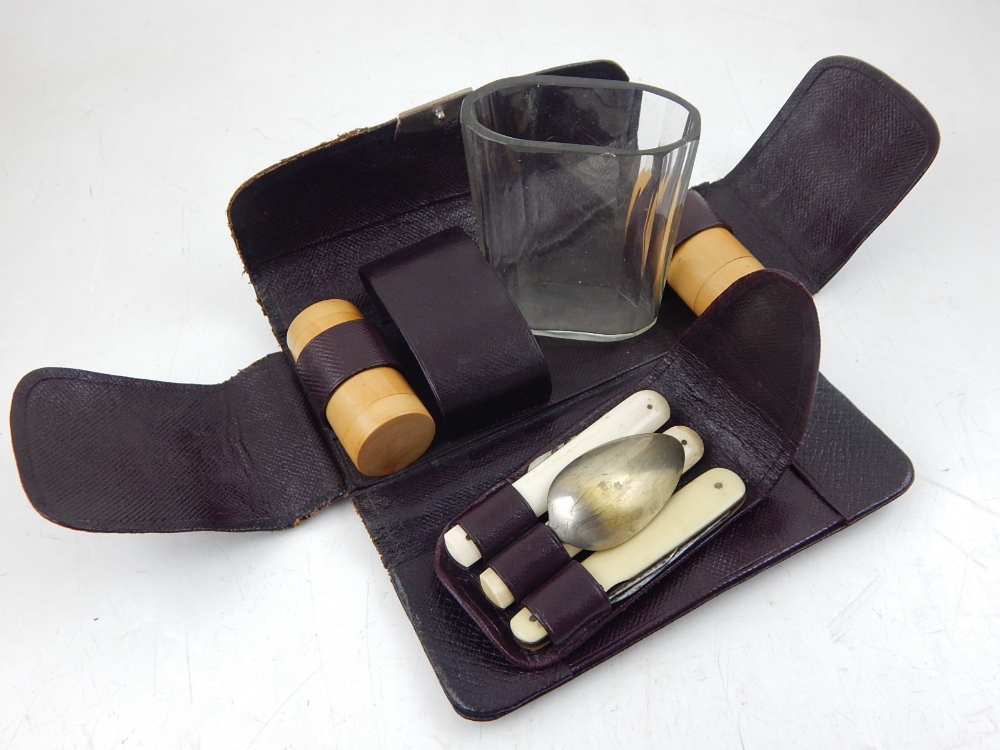 An early 20th century campaign set, the burgundy leather pouch housing a boxwood cruet,