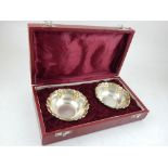 A pair of cased modern silver gilt bonbon dishes, with embossed grape borders.