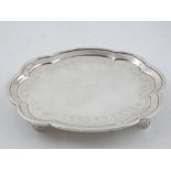 A George III silver card tray, with shaped border, raised on four feet, hallmarked London 1796,