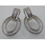 A pair of white metal and cubic zirconia doughnut style earrings, stamped 925.