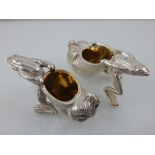 A pair of silver plated novelty salts modelled as frogs pulling snail shells. L.