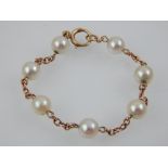 A pearl bracelet, the beads mounted between a fine chain, the link stamped 9ct, 5.