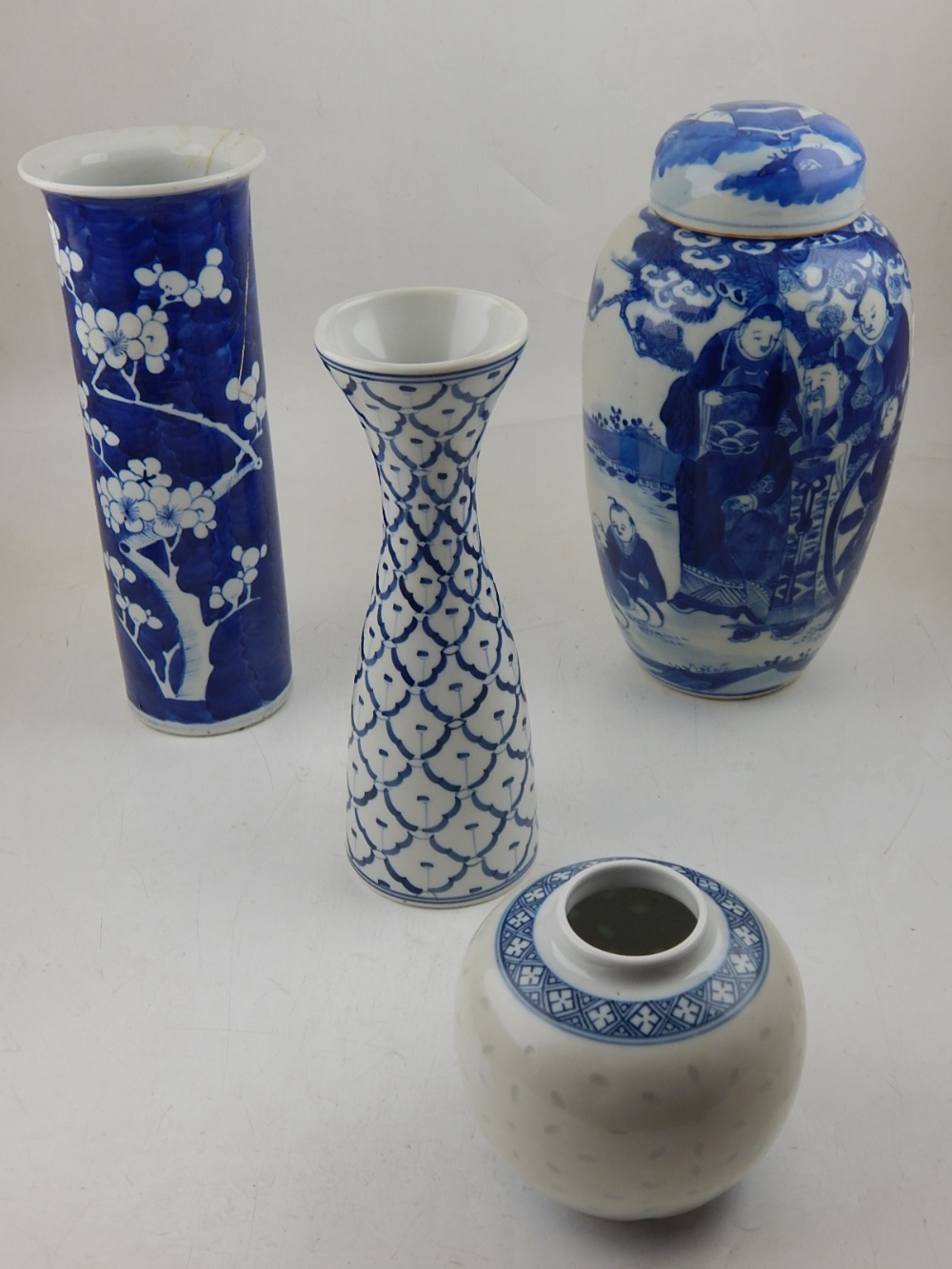 A blue and white Kangxi style porcelain tapered vase, decorated with flowers on a blue ground,