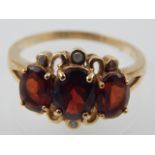 A 9ct yellow gold, garnet and diamond dress ring.