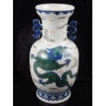 A Chinese twin handled porcelain vase, decorated with green dragons to front and back chasing pearl,