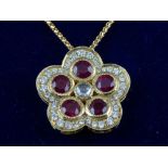 An 18ct yellow gold, ruby and diamond drop pendant necklace, modelled as a flower.