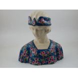 An Art Deco style ceramic bust of a lady, with floral print headdress. H.