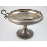 A silver shallow dish, Sheffield 1924, with twin serpent handles and raised on a circular foot 15.