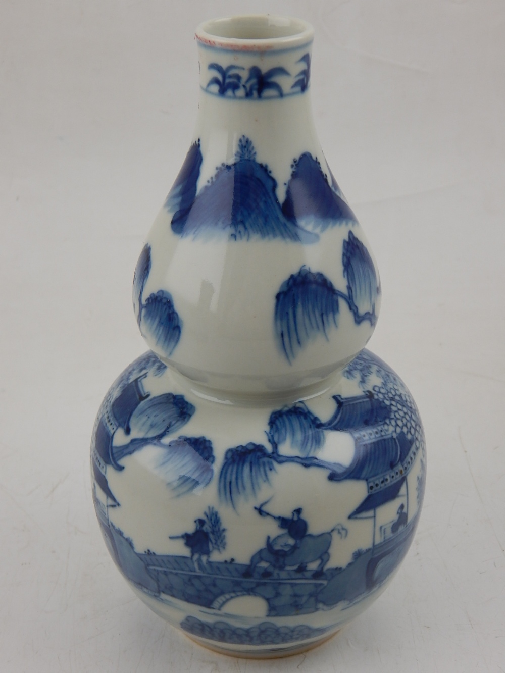 A Chinese blue and white double gourd vase, decorated with a village in a mountainous landscape,