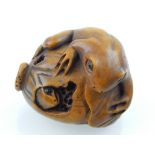 A Japanese carved boxwood netsuke modelled as two toads eating a fruit, bears character mark. L.
