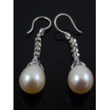 A pair of white gold, diamond, and pearl drop earrings.