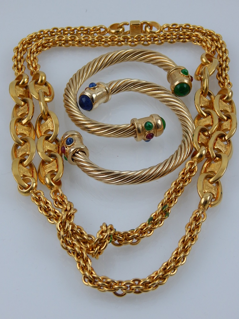 Celine. Paris. A gilt chain necklace, together with two gilt bangles set with blue, red and green