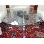 A contemporary glass top table, the base with a central brass cube and shaped acetate legs. D. 90cm