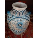 A large oriental terracotta blue and white glazed vessel, decorated with dragons, clouds and