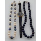 A strand of white and black natural pearls, with floral white metal clasp, together with another